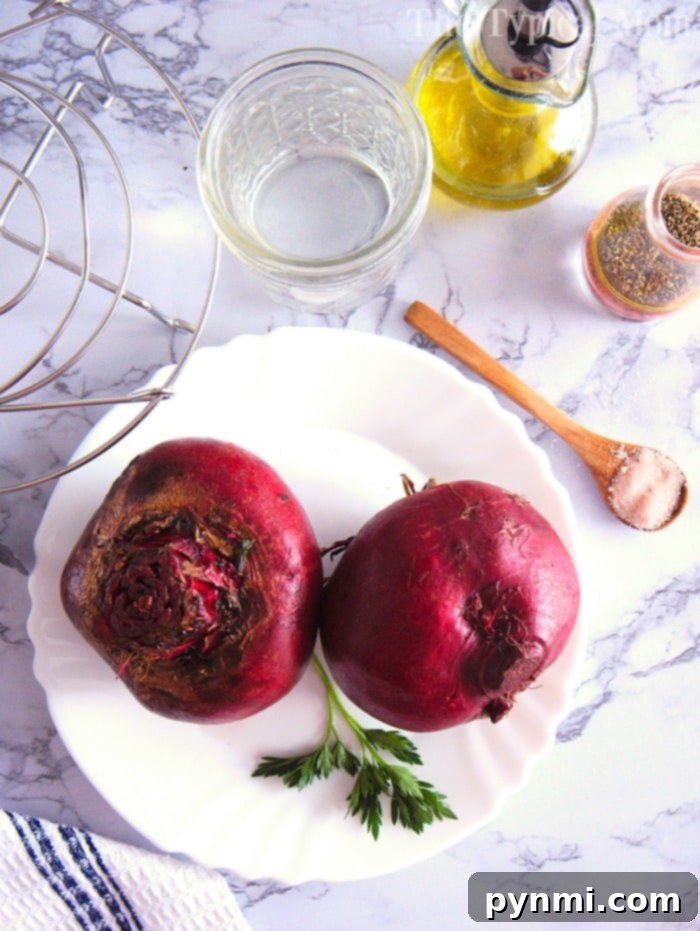 Instant Pot beets are the best vegetable. #instantpot #beets #beetrecipes #instantpotrecipes #pressurecooker #vegetables #healthy Two whole instant pot beets rest on a plate with parsley, accompanied by a glass of water, oil, spices, and a spoon on the marble surface.