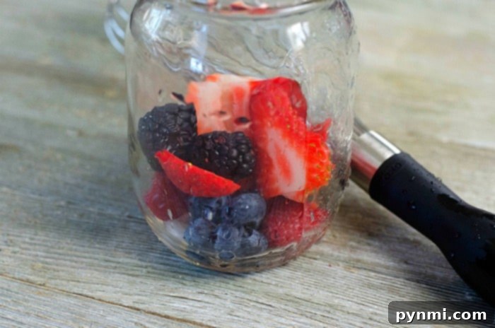 A refreshing berry mojito garnished with fresh fruit and mint.
