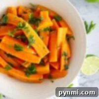 Perfect Pressure Cooker Carrots 3 Pressure cooker carrots, sliced and cooked to perfection, are garnished with chopped parsley in a white bowl on a marble surface with lime nearby.