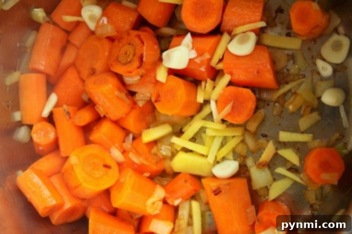 A bowl of the best carrot soup garnished with fresh herbs