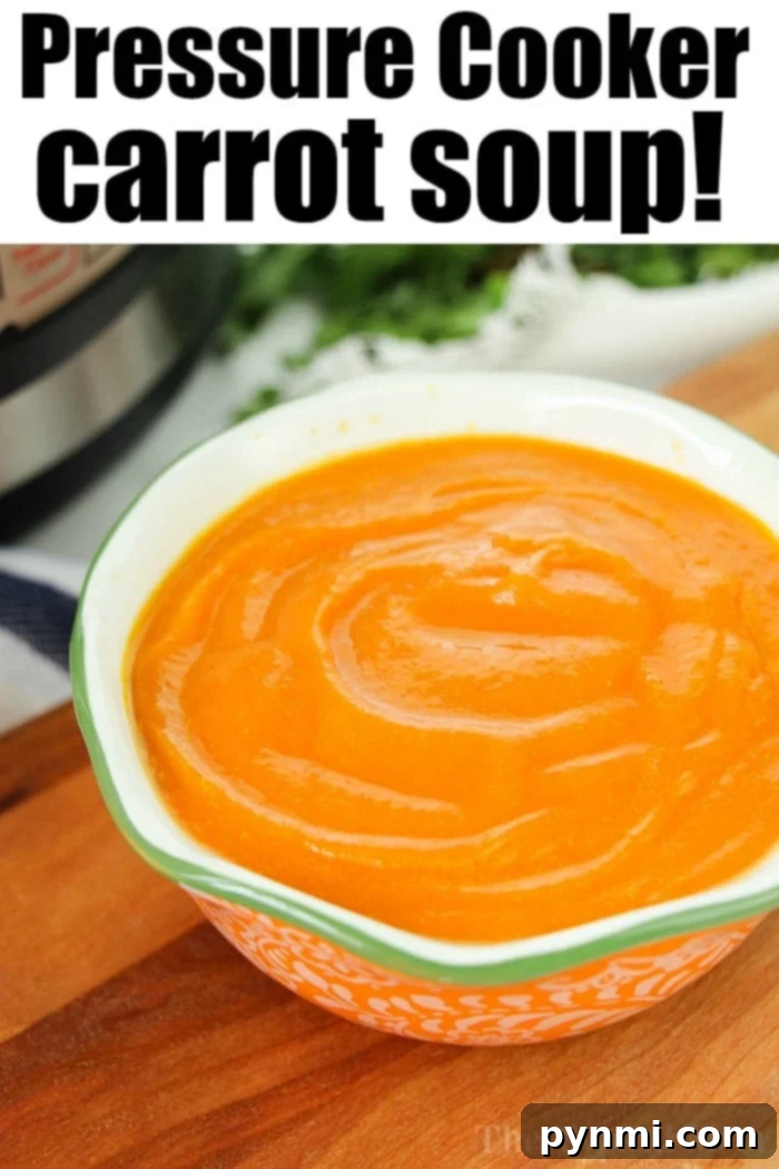 A bowl of smooth orange carrot soup on a table, ready to be enjoyed.