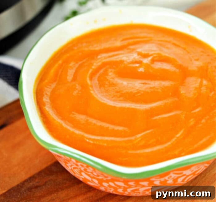A large pot of vibrant orange carrot soup, a comforting and healthy meal.
