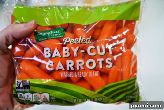 Transforming Carrots Simple Steps to Deliciousness 3 A hand holding a bag of peeled baby-cut carrots labeled "Signature Farms Quality Guaranteed." The bag states "Washed & Ready to Eat" and includes a Non-GMO Project Verified mark, perfect for those wondering how to cook carrots quickly. The bag size is 16 oz (1 lb) / 454 g.