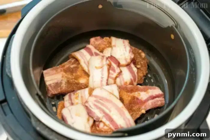 Juicy Pork Chops Wrapped in Crispy Bacon 2 Bacon-wrapped air fryer pork chops ready to cook