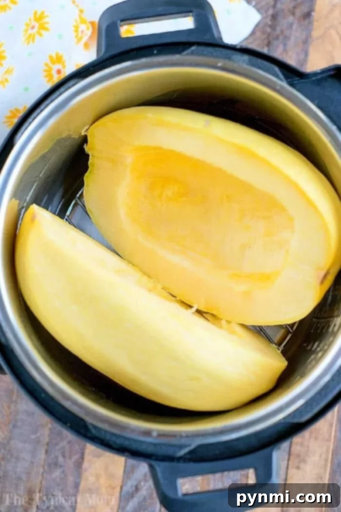 Halved spaghetti squash, a quintessential summer ingredient, ready to be cooked in an Instant Pot, resting on a rustic wooden surface. Its vibrant yellow flesh promises a healthy and delicious meal.
