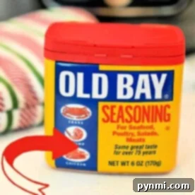 Old Bay Seasoning container showcasing its perfect pairing with seafood, poultry, salads, and meats. A red arrow highlights crab, shrimp, and chicken. Discover how to make Old Bay from scratch to enhance each dish with authentic flavor at home.