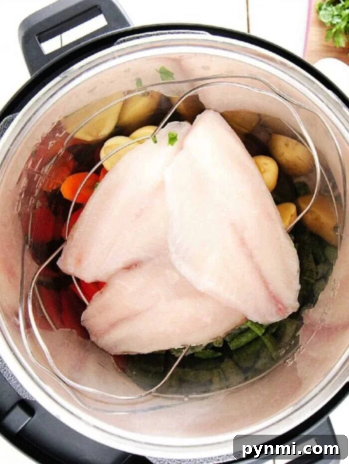 Frozen tilapia fillets and colorful vegetables ready to be cooked in an Instant Pot.