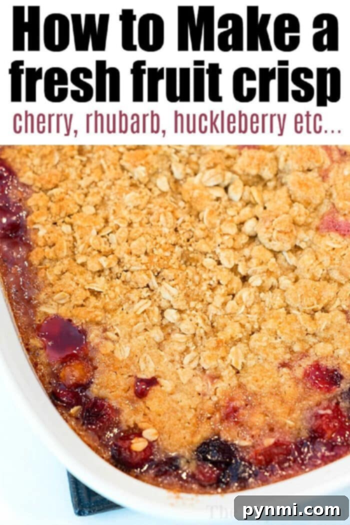 This cherry crisp recipe is easy to throw together and can be made with fresh pie cherries too! If you love cobbler for dessert, this is going to be a hit. #cherrycrisp #cherryrecipes #cherrydessert #dessert #cherrycobbler #cobbler Golden brown cherry crisp recipe with oats on top and visible cherry, rhubarb, and huckleberry filling in a white dish, ready to be served.
