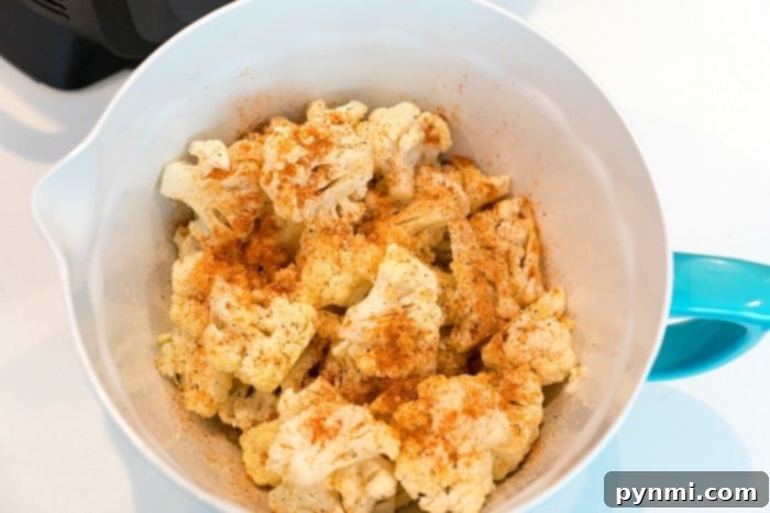 Crispy 3 Close-up of golden-brown air-fried cauliflower in a Ninja Foodi basket, highlighting its crispy texture.
