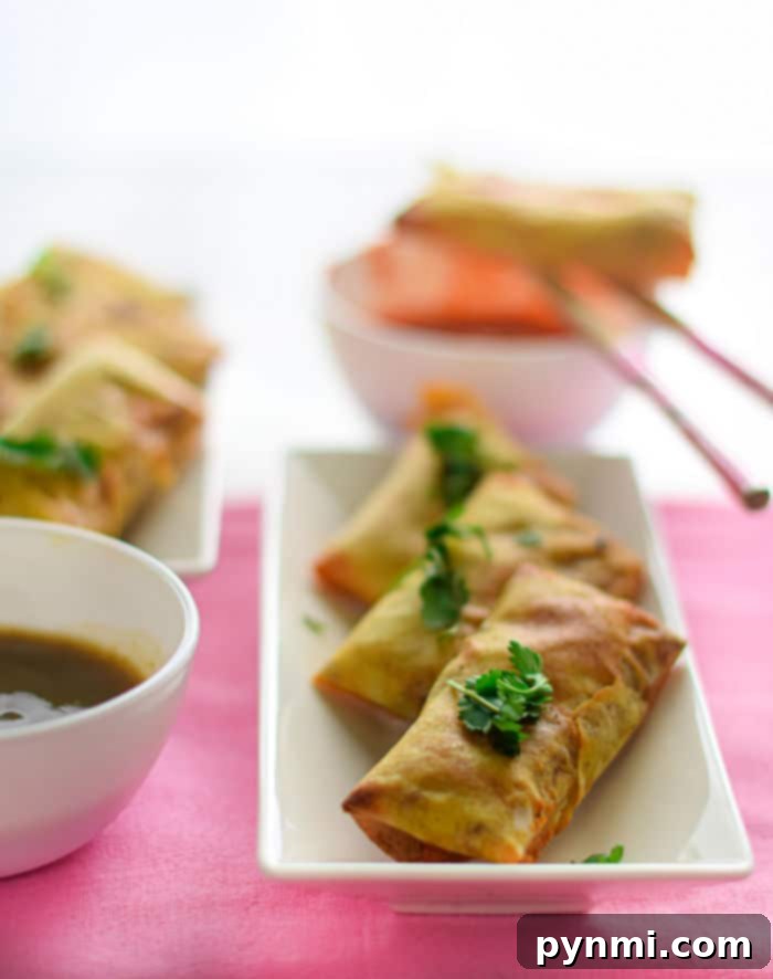 A freshly made batch of homemade egg rolls, golden and crispy, arranged on a serving plate, inviting to be eaten.