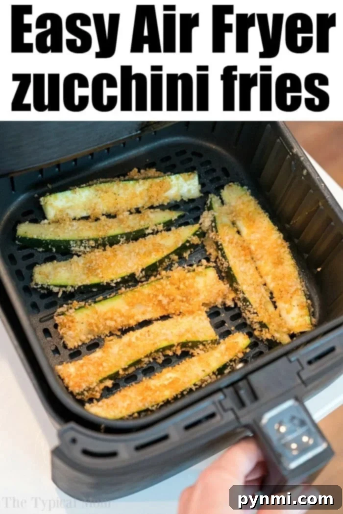 A close-up of air fryer zucchini fries coated in breadcrumbs cooking in an air fryer basket. The text at the top reads "Easy Air Fryer zucchini fries," and a hand is shown holding the air fryer drawer.