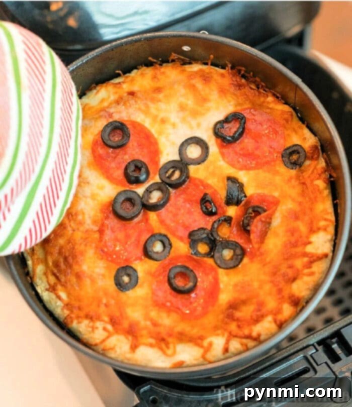 Homemade air fryer pizza with golden crust and melted cheese, topped with pepperoni.