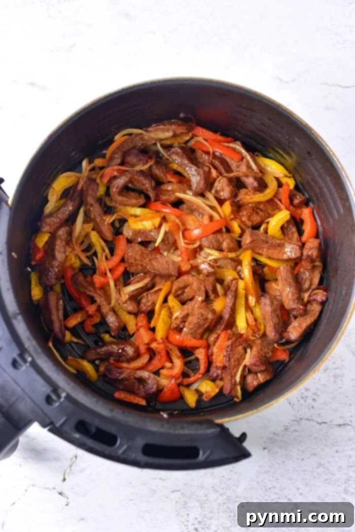 Air Fryer Beef Fajitas are so easy to make! We used beef with a dry rub, onions and bell peppers and they were great in our Ninja Foodi and Cosori machines. #airfryer #airfryerrecipes #fajitas #beef #dinner #healthy #lowcarb #keto ninja foodi air fryer fajitas
