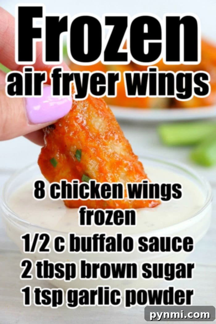 Crispy Air Fryer Frozen Chicken Wings 11 Close-up of a hand dipping a buffalo chicken wing into sauce. Discover the ultimate air fryer recipe for turning frozen chicken wings into crispy, savory bites.