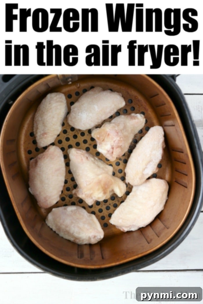 Crispy Air Fryer Frozen Chicken Wings 5 Frozen chicken wings in an air fryer basket, ready to be perfectly cooked, promise a crispy delight with minimal effort.