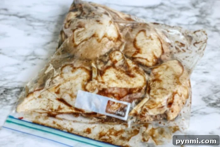One-Pan Crispy Chicken Thighs 3 Chicken thighs marinating in a flavorful sauce in a plastic bag.