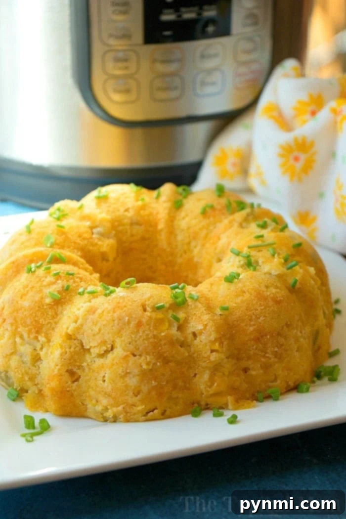 A delicious Instant Pot corn casserole recipe, presented as a bundt cake, golden brown and garnished with fresh herbs.
