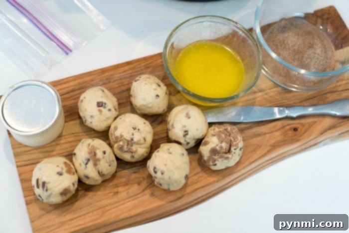 Fluffy Air Fryer Donut Bites 3 Cinnamon roll donut balls being prepared on a counter, ready for the air fryer.
