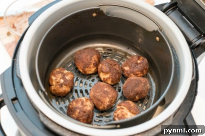 Fluffy Air Fryer Donut Bites 4 Delicious air fryer donuts coated in cinnamon sugar, ready to be glazed.