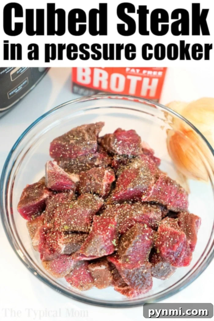 Instant Pot cubed steak and mushroom gravy recipe is the bomb! Tender sirloin or stew meat in your pressure cooker packed with flavor everyone will love. #instantpot #thetypicalmom #beeftips #beef #gravy #cubedsteak #steak #pressurecooker #ninjafoodi Bowl of seasoned raw steak next to broth and onion, with an Instant Pot in the background, ready for delicious beef tips.