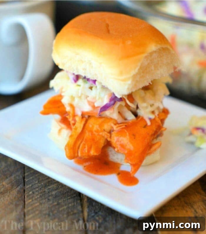 Flavor-Packed Slow Cooker Buffalo Sliders 2 Delicious Crockpot Buffalo Chicken Sliders served on mini buns, garnished with fresh herbs, perfect for a party appetizer or easy dinner.