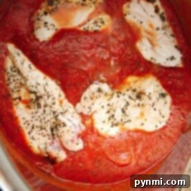 Chicken breast slices in a tomato sauce, garnished with herbs, create a delightful instant pot chicken parmesan.