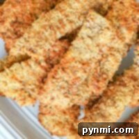 Crispy, golden-brown chicken fried steak in air fryer elegantly arranged on a white plate.