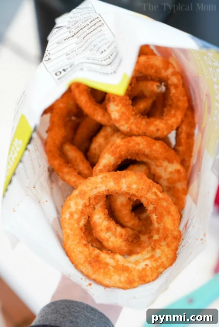 Perfectly Crispy Air Fryer Frozen Onion Rings 4 A vibrant close-up of golden, crispy air fryer frozen onion rings piled high on a serving plate, inviting a delicious bite.