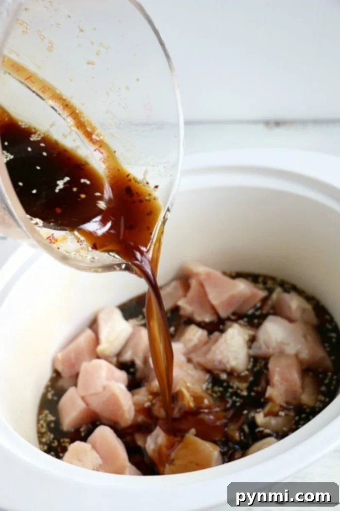 Crockpot sesame chicken recipe is here! Sticky honey sweet chicken thighs or breasts with a kick served on top of a bed of rice will be your favorite slow cooker meal. #crockpot #crockpotrecipes #sesamechicken #chicken #crockpotchicken #honey Hearty Crockpot honey sesame chicken, ready to be served.