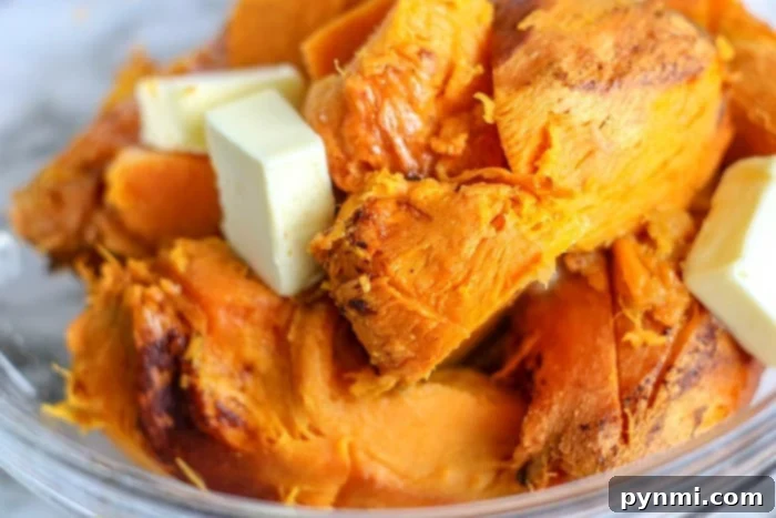 A large white bowl filled with creamy mashed sweet potatoes, ready to be served.