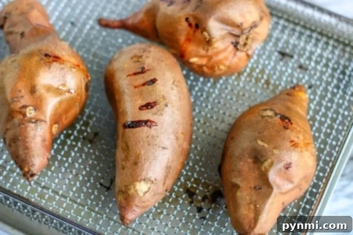 Close-up of raw sweet potatoes, illustrating how to cook them whole in an air fryer for mashing.