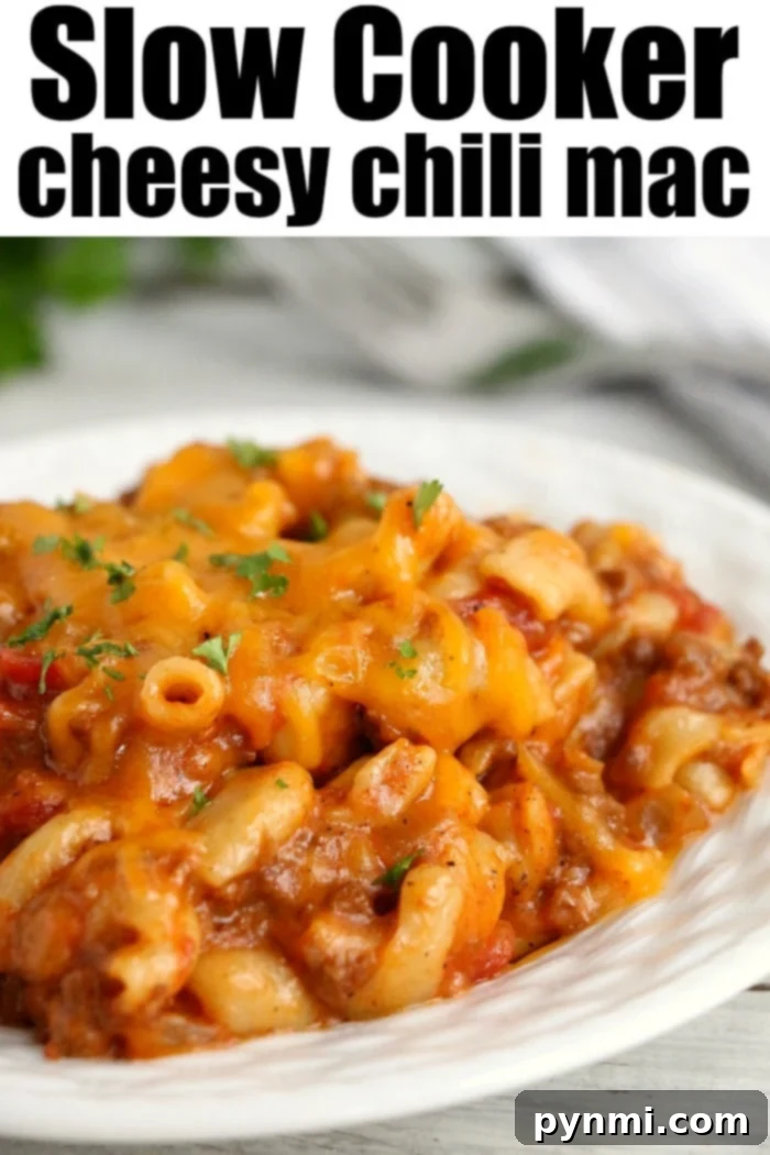 Delicious Crockpot Chili Mac in a slow cooker, topped with melted cheese, ready to serve.