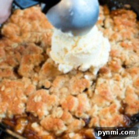 Skillet-Baked Apple Crisp with Toasted Oats 9 Scooping vanilla ice cream onto a freshly baked apple crisp in a cast iron skillet brings the delightful aroma of warm spices and fruit, much like a classic cast iron apple crisp.