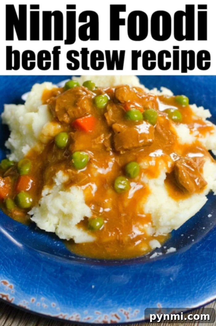 A plate of Ninja Foodi beef stew brimming with peas and carrots sits invitingly over mashed potatoes on a blue plate.