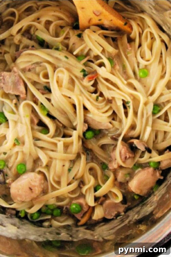 Creamy Instant Pot Turkey Tetrazzini 2 A delightful bowl of creamy pasta with chicken, mushrooms, and peas, reminiscent of an Instant Pot turkey tetrazzini, ready to be enjoyed.