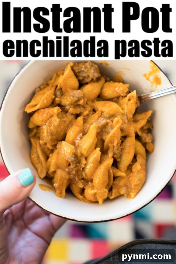 Instant Pot enchilada pasta is a creamy pasta with ground beef and all the Mexican flavors you love. Cooked in 4 minutes, you'll want seconds. #instantpotrecipeseasy #instantpot #enchiladacasserole #instantpotpasta #enchiladapasta #thetypicalmom Instant Pot Enchilada Casserole served in a bowl, showing creamy pasta and meat.