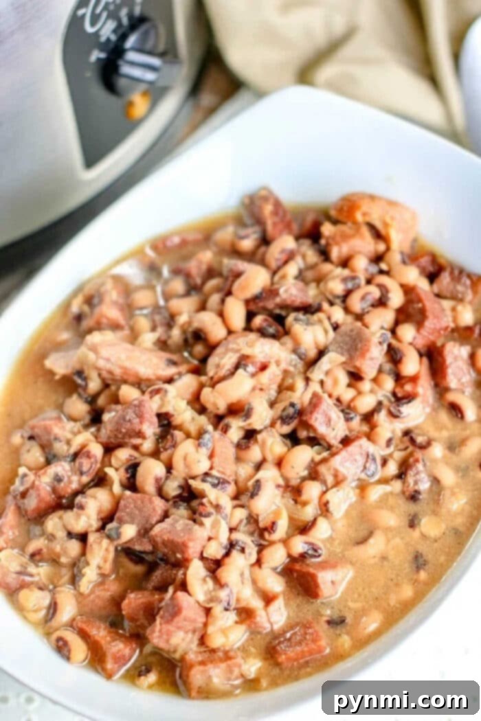 A vibrant bowl of Slow-Cooker Black-Eyed Peas with ham, garnished with fresh parsley.