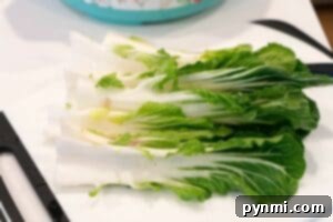Fresh bok choy, washed and halved, displayed on a white cutting board—perfect for learning how to make bok choy dishes at home.