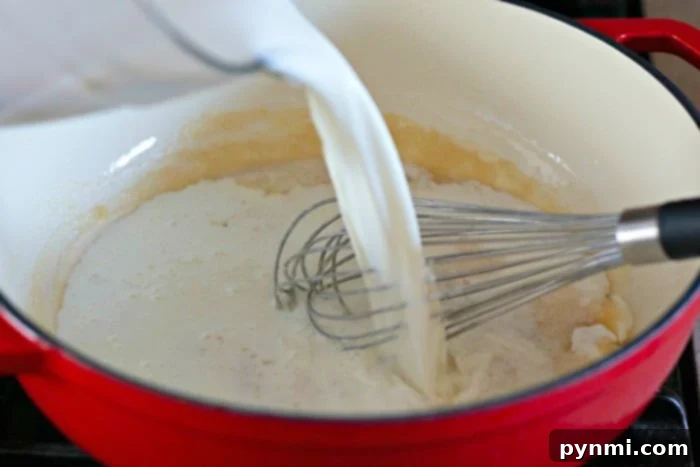 Silky smooth homemade cheese sauce simmering in a Dutch oven, ready for macaroni.