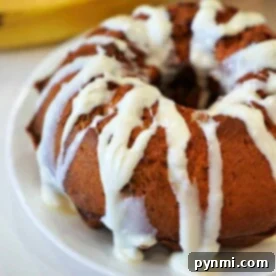 Air Fryer Breakfast Delights 9 A glazed bundt cake sits enticingly on a white plate, with a banana in the background, hinting at a perfect air fryer breakfast treat.