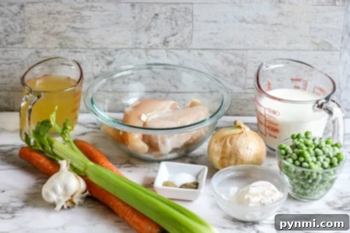 Ingredients for Ninja Foodi chicken pot pie, including fresh vegetables, chicken, and seasoning.