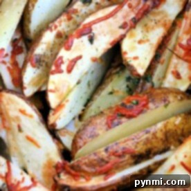 Crispy Air Fryer Potato Wedges 3 Close-up of seasoned air fryer potato wedges with herbs and shredded cheese.