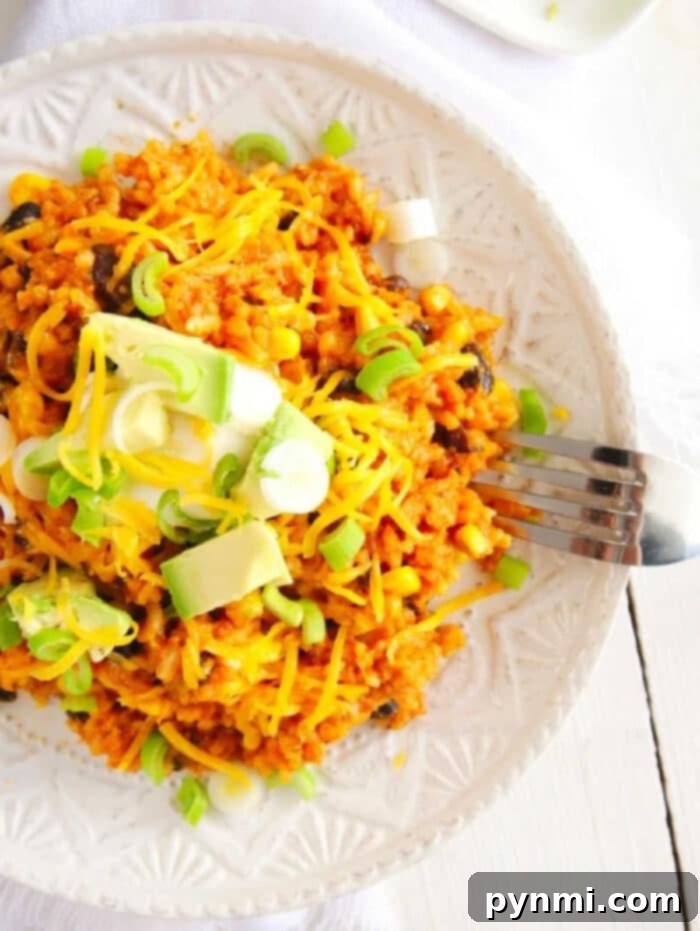 A close-up shot of vibrant Instant Pot Enchilada Rice in a serving dish, garnished with fresh cilantro, ready to be enjoyed as a hearty side or main course. The rich red sauce, tender rice grains, and colorful beans and corn are clearly visible.