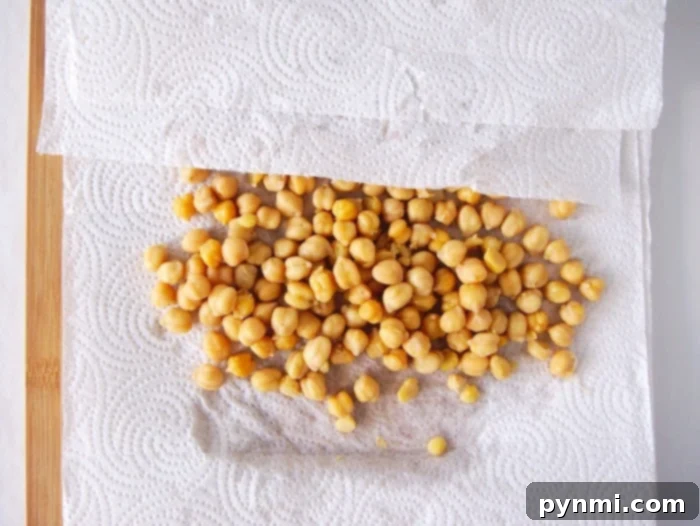 Ultimate Air Fryer Chickpea Crunch 4 Baked chickpeas spread out on a baking sheet, showcasing their golden texture.