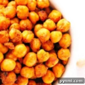 A close-up view of a bowl filled with golden brown, crispy air fryer chickpeas, perfectly roasted and seasoned to perfection.