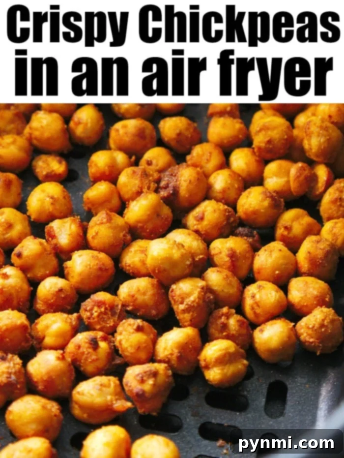 Air fryer chickpeas are crispy high protein snacks with tons of flavor. Tossed in taco seasoning they cook in no time. You'll love bringing these on the go. #airfryerchickpeas #chickpeas #airfryer #airfryerrecipes #ninjafoodi Close-up image of air fryer chickpeas in a basket. The golden brown chickpeas look perfectly seasoned. Text at the top reads "Crispy Chickpeas in an Air Fryer.
