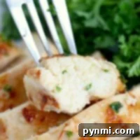 A fork holds a piece of juicy chicken breast, perfectly cooked in the Ninja Foodi, garnished with chopped herbs. The chicken is sliced with visible grill marks. Fresh green parsley or cilantro adorns the background, enhancing its visual appeal.