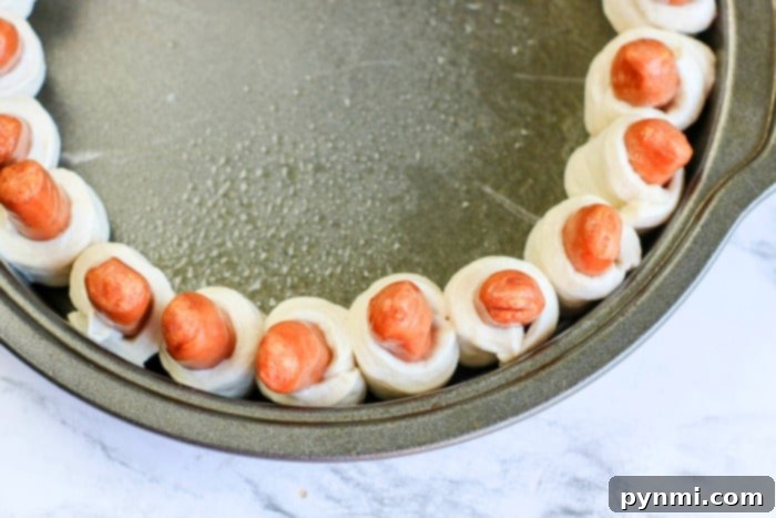 Close-up of baked pigs in a blanket with a golden, crispy crust, perfectly ready for dipping and enjoying.