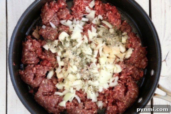 Perfect Air Fryer Stuffed Peppers 4 Close-up of seasoned ground beef cooking in a pan.