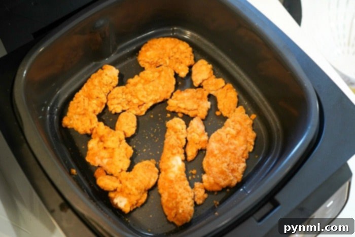 Air Fryer Frozen Chicken Tenders: Crispy Perfection 2 Frozen Chicken Strips Arranged in Air Fryer Basket